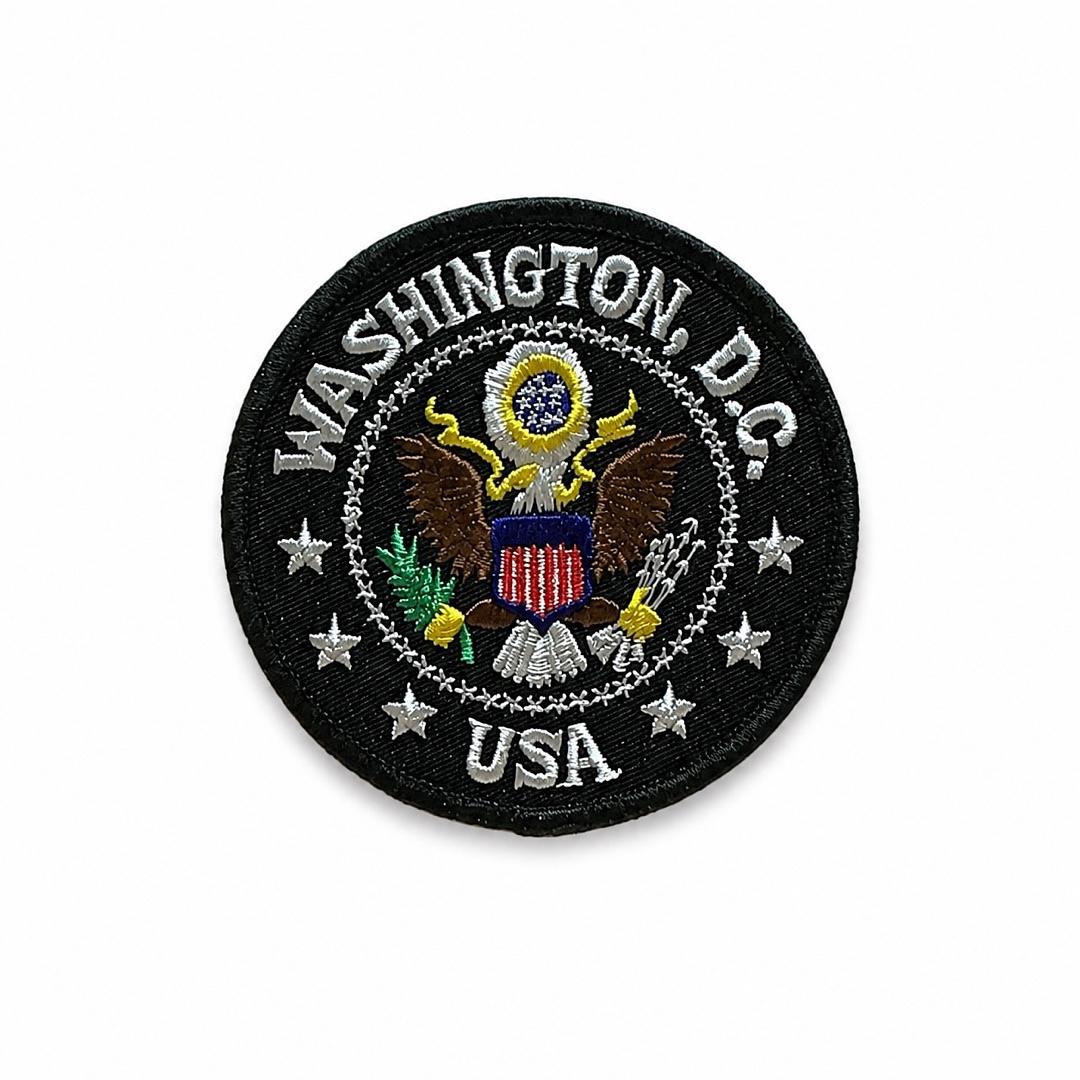A circular embroidered United States District of Columbia patch featuring the official seal with an eagle, shield, and stars on a black background.