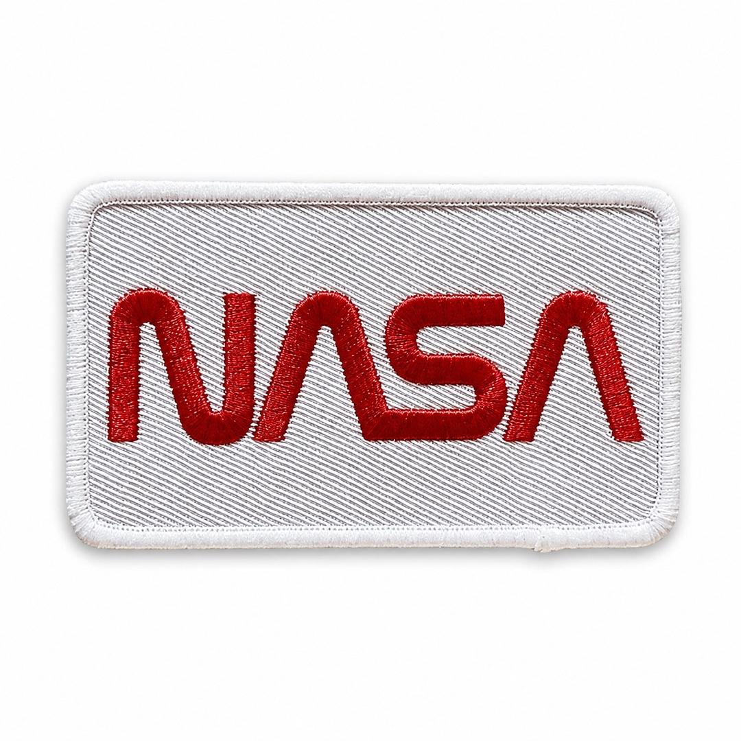 A rectangular embroidered patch featuring the red NASA logo on a white stitched background with a white border.