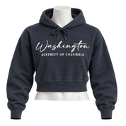 A cropped navy blue hoodie displayed on a white mannequin torso against a plain white background. The hoodie features the words 'Washington' in a white cursive font and 'DISTRICT OF COLUMBIA' in a white block font on the chest.