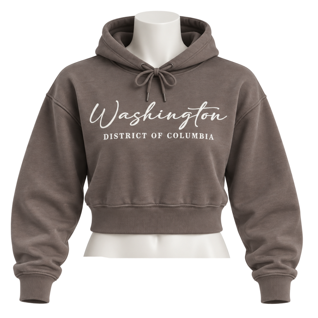 A cropped pullover hoodie in a muted taupe-brown color, displayed on a white mannequin torso. The hoodie features 'Washington' in white cursive script and 'DISTRICT OF COLUMBIA' in white block letters across the chest.