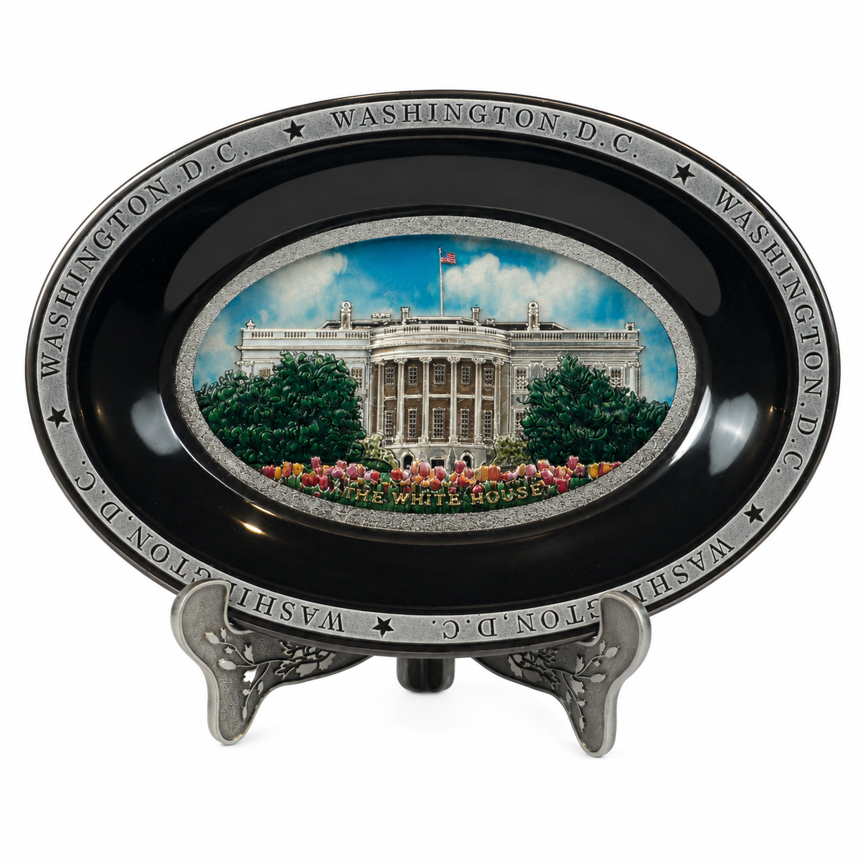A black oval ceramic plate featuring a detailed image of the White House with greenery, blue skies, and peach-colored flowers at the bottom.