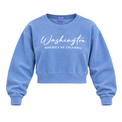 A light blue cropped crewneck sweatshirt with 'Washington District of Columbia' printed in white across the chest, displayed on a clean white background.