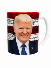 A white ceramic mug featuring a printed graphic of Donald Trump's smiling face over a distressed red, white, and blue American flag design with handwritten script details.