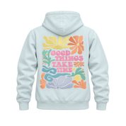 A light mint hoodie shown from the back, featuring a colorful retro floral graphic with the text 'GOOD THINGS TAKE TIME' in pink letters.