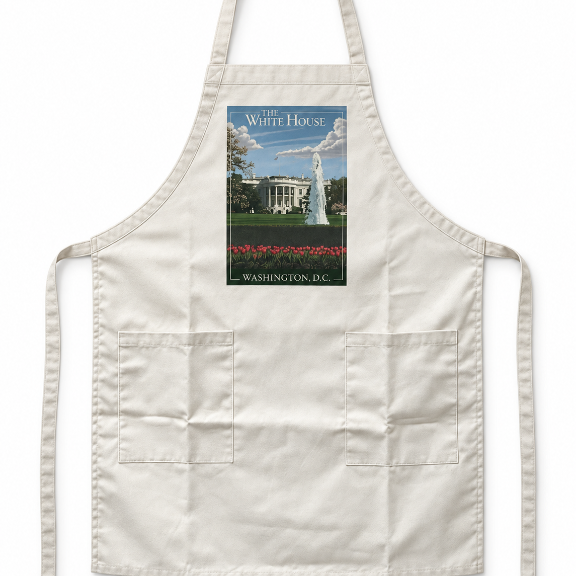 An off-white bib apron with two front pockets and neck strap, featuring a rectangular graphic print of the White House and its fountain on the chest.