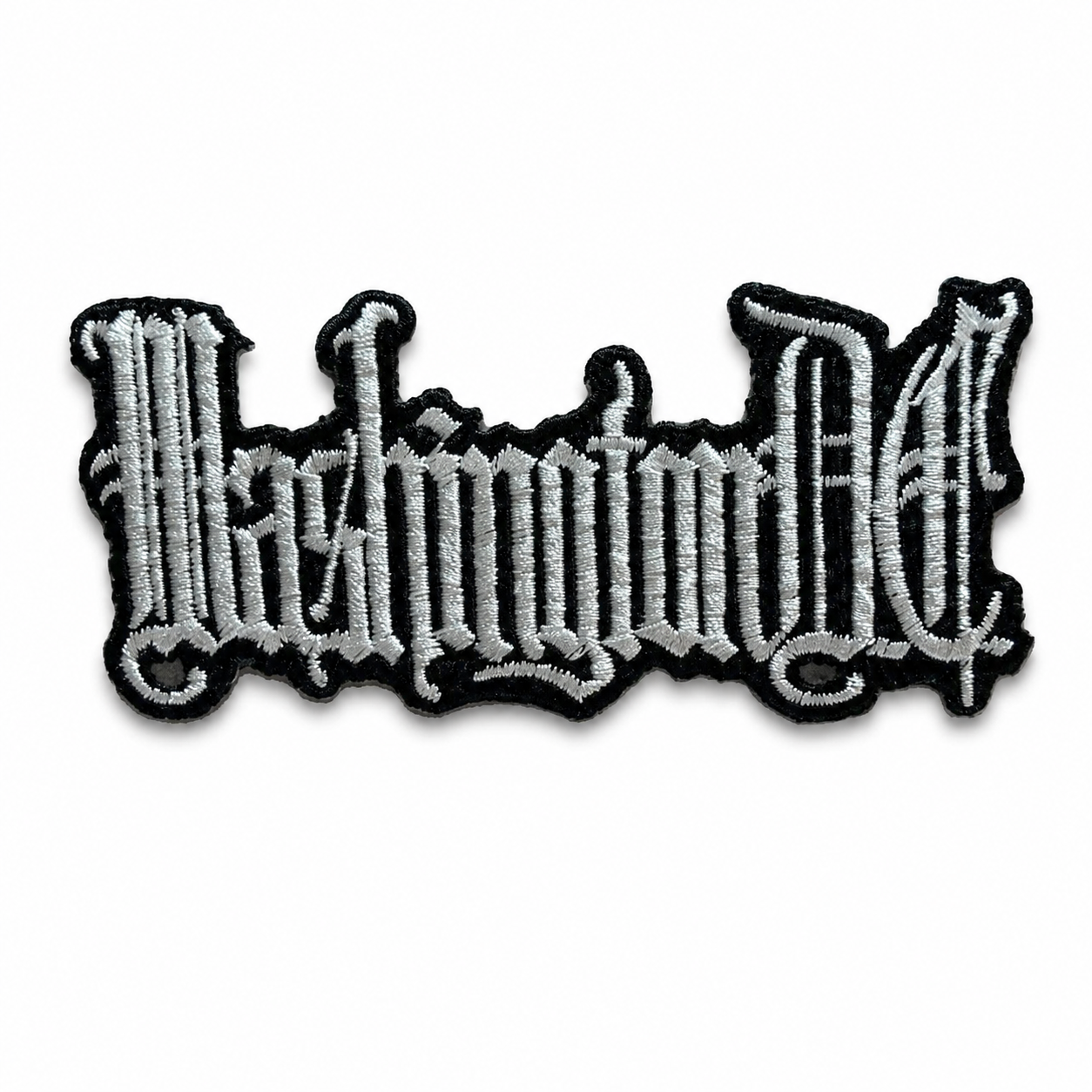An embroidered iron-on patch featuring the word 'Washington DC' in a stylized gothic font, with white embroidery, a black outline, and a subtle drop shadow on a plain white background.