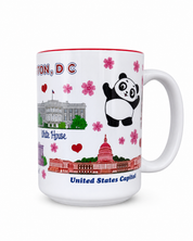 A white ceramic coffee mug with a red interior rim, decorated with illustrations of the White House and United States Capitol.