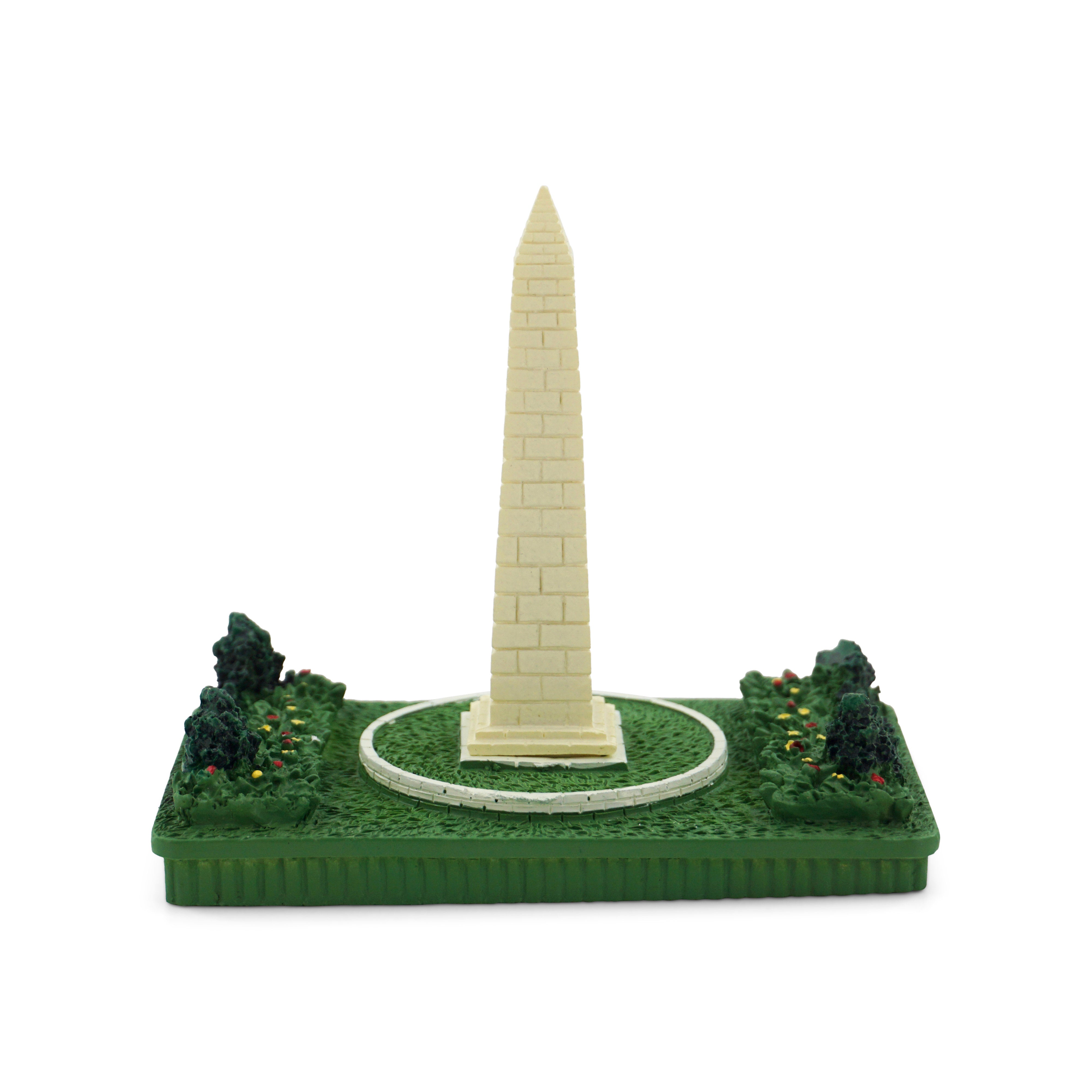 Model of the Washington Monument on a green base with trees