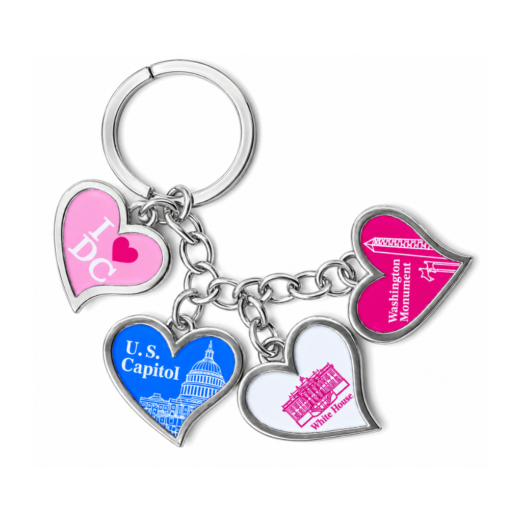 A silver metal keychain with four heart-shaped charms featuring Washington DC landmarks and text: 'I <3 DC' in pink, 'U.S.