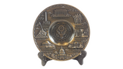 A pewter plate featuring the U.S. Seal in the center with various landmarks of Washington, D.C. around it.
